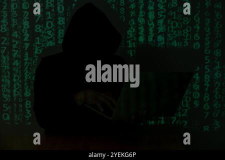 Hacker über einen Bildschirm mit Binärcode. Konzept eines Hackerangriffs Stockfoto