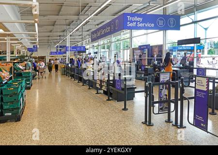 Breite Gänge und Möglichkeiten für Käufer, für Supermarkt-Lebensmittel-Shopping zu bezahlen, einschließlich Trolley Self Service auf glattem, sauberem Terrazzo-Boden London England UK Stockfoto