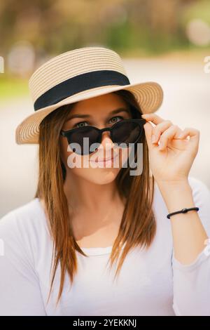 Porträt einer jungen attraktiven, modischen Frau mit Sonnenhut und Sonnenbrille Stockfoto