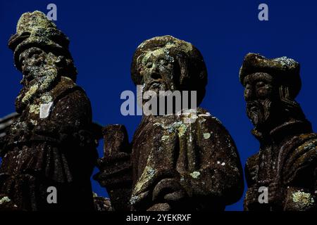 Feierliche Gesichter im Detail aus der Szene des Beombment of Christ, die Ende der 1500er Jahre auf einem Kalvarium in der Pfarrei nahe der Eglise Saint-Miliau im Dorf Guimiliau, Finistère, Bretagne, Frankreich, gemalt wurde. Stockfoto