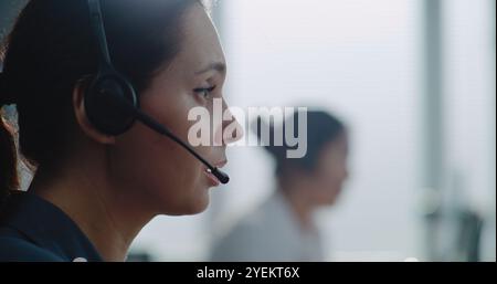 Nahaufnahme einer weißen Hotline-Betreiberin im Headset, die sich auf Abruf mit dem Kunden unterhalten und dem Kunden Online-Hilfe zur Verfügung stellen. Spezialist für technischen Support im Callcenter-Büro. Stockfoto