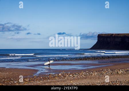 Einsamer Surfer macht sich auf den Weg zu den Breakers auf Saltburn Scar. Stockfoto