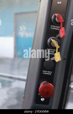 Detailansicht eines Staplerbedienfelds mit beladener Reichweite mit beschrifteten Schaltern und Not-aus-Taster, die für den Frachtumschlag unerlässlich sind. Stockfoto