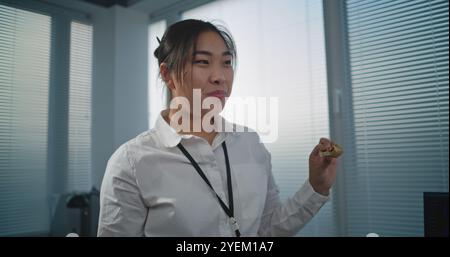 Modernes und ausgestattetes Callcenter-Büro: Multiethnisches Team von technischen Kundendienstspezialisten spricht und isst Pizza zum Mittagessen. Gruppe von Mitarbeitern des Unternehmens, die während der Pause ruhen. Stockfoto