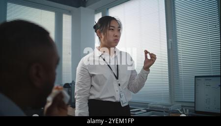 Modernes und ausgestattetes Callcenter-Büro: Multiethnisches Team von technischen Kundendienstspezialisten spricht und isst Pizza zum Mittagessen. Gruppe von Mitarbeitern des Unternehmens, die während der Pause ruhen. Stockfoto