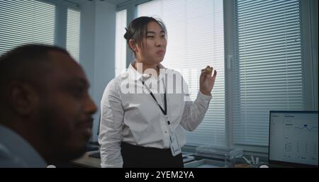 Modernes und ausgestattetes Callcenter-Büro: Multiethnisches Team von technischen Kundendienstspezialisten spricht und isst Pizza zum Mittagessen. Gruppe von Mitarbeitern des Unternehmens, die während der Pause ruhen. Stockfoto