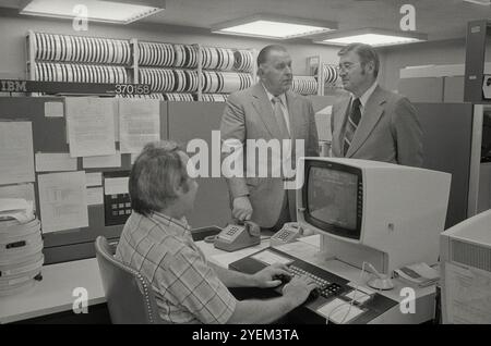 Frank Nordhoff (F. Nordy) Hoffman, Senat Sergeant at Arms (links) mit Mann am Computer. USA. Am 3. Mai 1977 Frank Nordhoff „Nordy“ Hoffman (1909–1996) war ein US-amerikanischer College-Fußballspieler an der University of Notre Dame, wo er 1978 mit der Wahl in die College Football Hall of Fame als All-American Garde in den Jahren 1930 und 1931 gedenkt wurde. Von 1975 bis 1981 war er Sergeant at Arms des Senats der Vereinigten Staaten. Stockfoto