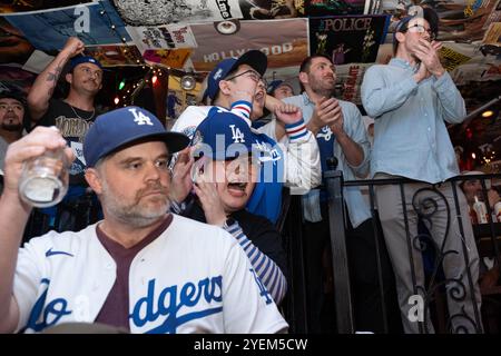 New York City, Usa. 30. Oktober 2024. Eine Gruppe von Fans jubelt auf die Treppe, während die Dodger's ihre Führung 7-6 sichern. Feiern Sie den Sieg der Los Angeles Dodger's World Series in Spiel 5 über die New York Yankees am 30. Oktober 2024 im Taqueria St Marks Place in Manhattan, New York City. (Foto: Derek French/SOPA Images/SIPA USA) Credit: SIPA USA/Alamy Live News Stockfoto