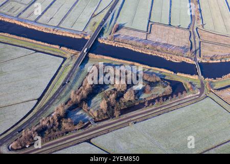 Blick aus der Vogelperspektive über die niederländische Landschaft Alblasserwaard mit gefrorenen Wiesen, Autobahn und Kanal Stockfoto