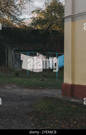 Die Wäsche trocknet draußen im alten sowjetischen Innenhof. Die Kleidung trocknet draußen Stockfoto