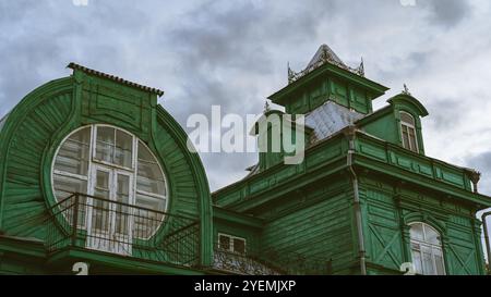 Ein grünes, hölzernes, altes Gebäude von ungewöhnlicher Form Stockfoto