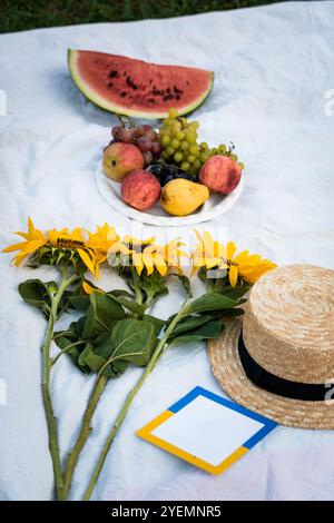 Erfrischendes Sommerpicknick mit Früchten und Sonnenblumen. Stockfoto