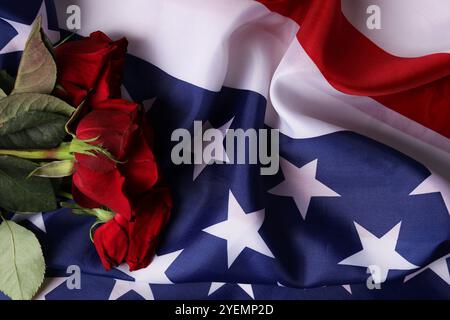 Veteranentag. Rosenblumen auf amerikanischer Flagge, Draufsicht Stockfoto