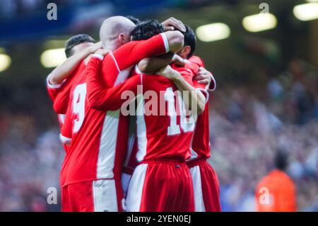 Die walisischen Spieler feiern ein Tor in der dritten Minute von Mittelfeldspieler Simon Davies, der das 10-Trikot trägt. Qualifikationsspiel WALES gegen FINNLAND in Gruppe 9 für die 2004 Euro im Millennium Stadium in Cardiff, Wales, Großbritannien am 10. September 2003. Foto: ROB WATKINS. INFO: Die Qualifikation für die UEFA-Europameisterschaft 2004 in Wales war denkwürdig, aber letztlich herzzerreißend. Unter der Leitung von Manager Mark Hughes und mit Stars wie Ryan Giggs erreichten sie die Playoff-Phase, verpassten aber knapp die Qualifikation und verloren gegen Russland trotz starker Leistungen. Stockfoto