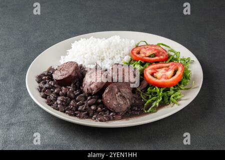 Teller mit traditioneller brasilianischer Feijoada auf grauem Hintergrund. Stockfoto