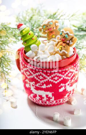 Weihnachten heiße Schokolade Tasse mit lustigen niedlichen Lebkuchen Mann aus Marschmau, Baden in Kakao Tasse, mit Weihnachten dekoriert weißen Tisch. Stockfoto