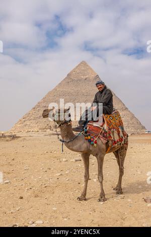 Gizeh Pyramidenkomplex, Al Ahram, Gizeh, Ägypten. Februar 2023. Mann auf einem Kamel vor der Pyramide von hafre. Stockfoto