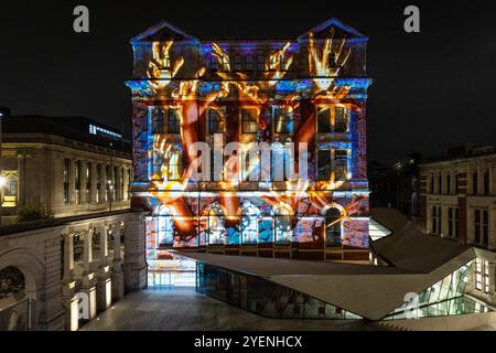 NUR Eine Vorschau eines eigens in Auftrag gegebenen KI-Kunstwerkes aus Ouchhh Studio, das mithilfe kognitiver Technologie zur Visualisierung von Gehirnwellen der Arts & Film erstellt wurde, wird über die Fassade des V&A Exhibition Road Courtyard Gebäudes in London projiziert, bevor es morgen Abend im Rahmen des 30. Geburtstages der National Lottery öffentlich enthüllt wird. Bilddatum: Donnerstag, 31. Oktober 2024. Stockfoto