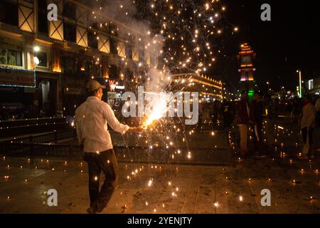 Srinagar, Indien. 31. Oktober 2024. Ein Hindu zündet Feuerknacker an, während er Diwali, das Lichterfest am Uhrturm im Stadtzentrum von Srinagar, der Sommerhauptstadt von Jammu und Kaschmir, feiert. Diwali, auch bekannt als Deepavali, und das „Festival der Lichter“, ist eines der beliebtesten Festivals des Hinduismus, das auf der ganzen Welt gefeiert wird. Es symbolisiert den spirituellen „Sieg des Lichts über die Dunkelheit, des Guten über das Böse und des Wissens über die Unwissenheit“. Quelle: SOPA Images Limited/Alamy Live News Stockfoto