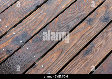 Blick von oben auf einen dunklen Holzfußboden mit rustikalen Körnern und Knoten Stockfoto