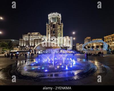 Nächtlicher Blick auf den singenden Brunnen (beleuchteter musikalischer Brunnen) auf dem Paweletskaja-Platz mit dem Paweletskaja-Turm in Moskau, Russland Stockfoto
