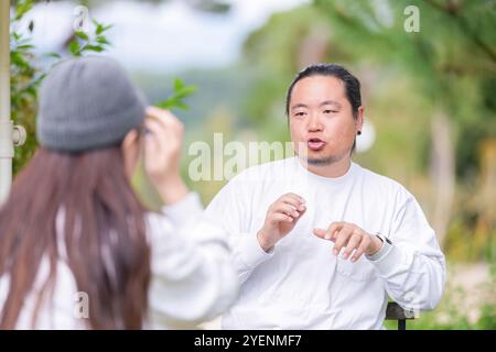 Ein koreanischer Mann und eine Japanerin, beide im Alter von 30 Jahren und ein verheiratetes Paar, genießen in einem stilvollen Café im Herbst einen Brunch mit drei Hunden Stockfoto