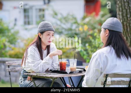 Ein koreanischer Mann und eine Japanerin, beide im Alter von 30 Jahren und ein verheiratetes Paar, genießen in einem stilvollen Café im Herbst einen Brunch mit drei Hunden Stockfoto