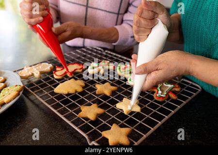 weihnachtskekse zusammen dekorieren, Seniorinnen, zu Hause. Urlaub, saisonal, kulinarisch Stockfoto