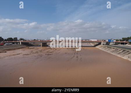 Die Folgen des Hurrikans Dana in Valencia, Spanien - Muddy River, der nach starkem Regen in Valencia unter der Brücke fließt Stockfoto