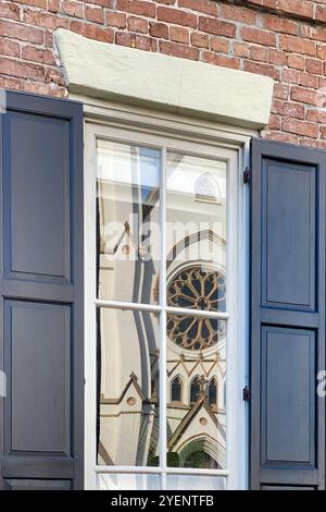 Fenster mit einer Reflexion der Kathedrale von St. Johannes dem Täufer, Savannah, Georgia Stockfoto