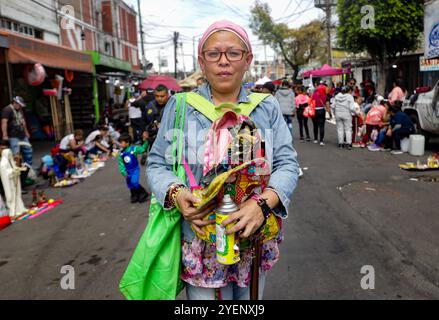 Mexiko-Stadt, Mexiko. 31. Oktober 2024. Ein Gläubiger besucht den Altar von Santa Muerte in der Alfareria Street im Stadtteil Tepito, um seine Hingabe zu zeigen und sich für die gewährten Gefälligkeiten zu bedanken. Gläubige von „Santa Muerte“, auch bekannt als „Niña Blanca“, besuchen das raue Viertel Tepito, um den 23. Jahrestag von Santa Muerte zu feiern. Am 31. Oktober 2024 in Mexiko-Stadt. (Foto: Ian Robles/ Credit: Eyepix Group/Alamy Live News Stockfoto