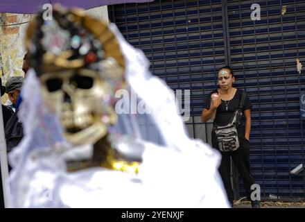 Mexiko-Stadt, Mexiko. 31. Oktober 2024. Ein Gläubiger besucht den Altar von Santa Muerte in der Alfareria Street im Stadtteil Tepito, um seine Hingabe zu zeigen und sich für die gewährten Gefälligkeiten zu bedanken. Gläubige von „Santa Muerte“, auch bekannt als „Niña Blanca“, besuchen das raue Viertel Tepito, um den 23. Jahrestag von Santa Muerte zu feiern. Am 31. Oktober 2024 in Mexiko-Stadt. (Foto: Ian Robles/ Credit: Eyepix Group/Alamy Live News Stockfoto