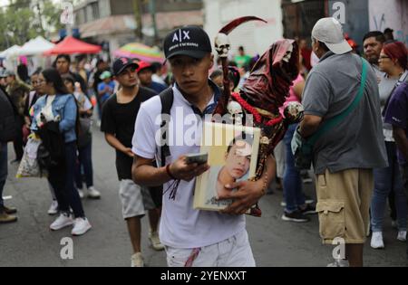 Ein Gläubiger besucht den Altar von Santa Muerte in der Alfareria Street im Stadtteil Tepito, um seine Hingabe zu zeigen und sich für die gewährten Gefälligkeiten zu bedanken. Gläubige von „Santa Muerte“, auch bekannt als „NiÃ±a Blanca“, besuchen das raue Viertel Tepito, um den 23. Jahrestag von Santa Muerte zu feiern. Am 31. Oktober 2024 in Mexiko-Stadt. (Kreditbild: © Ian Robles/OKULARIS via ZUMA Press Wire) NUR REDAKTIONELLE VERWENDUNG! Nicht für kommerzielle ZWECKE! Stockfoto