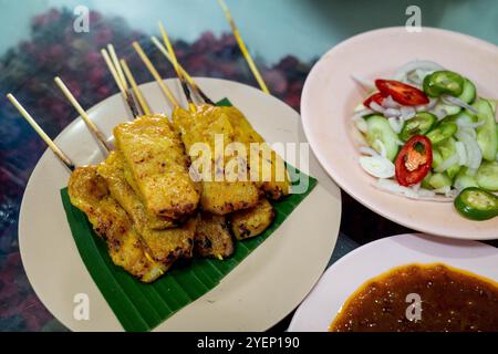 Satay-Sticks oder gegrilltes Schweinefleisch mit Gewürzen während des Abendessens im Hatyai, Thailand. Stockfoto