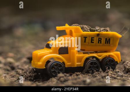Gelber Miniatur-Muldenkipper, der Erde und Schmutz transportiert Stockfoto