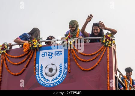 Dhaka, Bangladesch. 31. Oktober 2024. Die Mitglieder des Fußballteams der Frauen feiern auf ihrem Weg zum Bangladesch Football Federation House. Die Bangladesche Nationalmannschaft der Frauen hielt die SAFF Women's Championship Trophäe in einem offenen Bus auf dem Weg zum BFF House vom Hazrat Shahjalal International Airport aus. Quelle: SOPA Images Limited/Alamy Live News Stockfoto