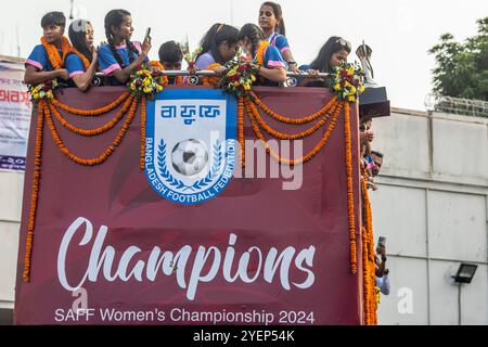 Dhaka, Bangladesch. 31. Oktober 2024. Die Mitglieder des Fußballteams der Frauen feiern auf ihrem Weg zum Bangladesch Football Federation House. Die Bangladesche Nationalmannschaft der Frauen hielt die SAFF Women's Championship Trophäe in einem offenen Bus auf dem Weg zum BFF House vom Hazrat Shahjalal International Airport aus. Quelle: SOPA Images Limited/Alamy Live News Stockfoto