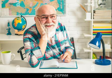 Heimschooling mit Großvater. Lehrer ist eine Wut des Spaßes. Die Lektion ist abgeschlossen. Studium der leitenden Pädagogen. Stockfoto