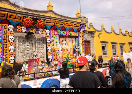 Am Vorabend des Día de los Muertos versammeln sich die Menschen in Frida Kahlos lebhafter Ofrenda in Jardín Plaza Hidalgo, Coyoacán, um die mexikanische Kultur zu feiern Stockfoto