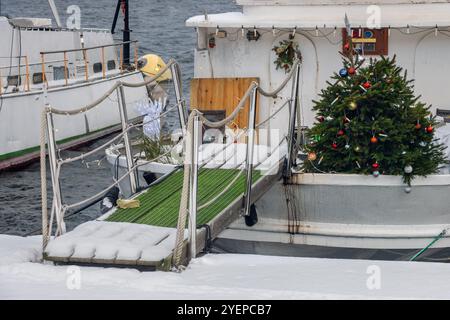 Weihnachtsbaum auf einem Boot, das an der Bank ankert Stockfoto