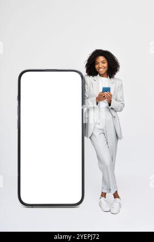 Glückliche junge afrikanische Geschäftsfrau, die in der Nähe eines großen Mock-Up-Smartphones steht. Stockfoto