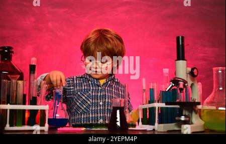 Kind im Klassenzimmer mit Tafel im Hintergrund. Schuljunge. Sie führten ein neues Experiment in Chemie durch. Wissenstag. Heimschulung Stockfoto