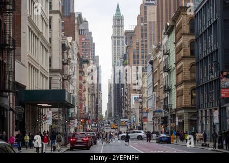 Dieses Foto zeigt eine geschäftige Straßenszene am Broadway in SoHo, New York City, eingerahmt von klassischen gusseisernen Gebäuden. Stockfoto