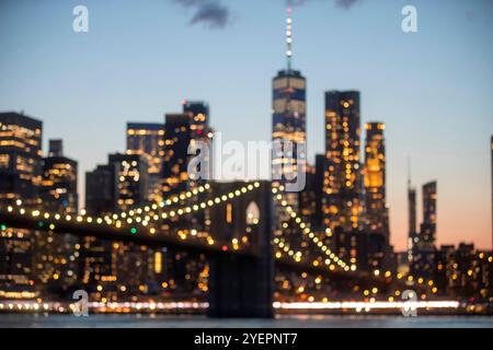 Verschwommener Blick auf die Brooklyn Bridge mit Skyline-Lichtern von New York City. Stockfoto