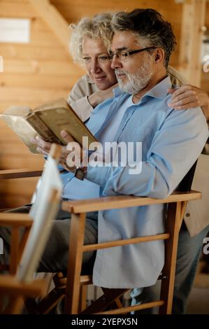 Seniorenpaar liest ein Buch in der Nähe zu Hause. Stockfoto