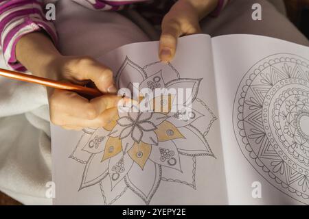 Frauen malen Anti-Stress-Seite. Weibliche Hand Malmandala. Weibliche Malmandalas zur Stressbekämpfung. Entspannendes Hobby, mentales Wohlbefinden und Art thera Stockfoto