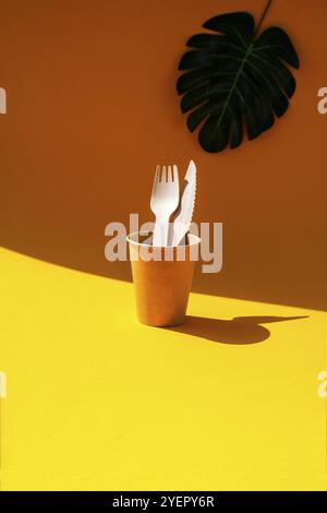 Holzgabeln und Pappbecher mit Tellern auf farbigem Hintergrund. Umweltfreundliches Einweggeschirr. Wird in Fast Food, Restaurants, Imbissbuden und Picknicks verwendet. Nein Stockfoto