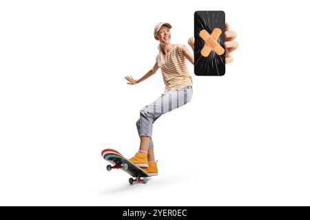 Eine Skaterin, die ein Longboard fährt und ein kaputtes Smartphone auf weißem Hintergrund hält Stockfoto