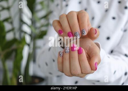 Gepflegte weibliche Hände mit stilvollen rosa Nägeln und Design. Trendige Maniküre in modernem Design. Gelnägel. Hautpflege. Schönheitsbehandlung. Nagelpflege. Wellness. Stockfoto