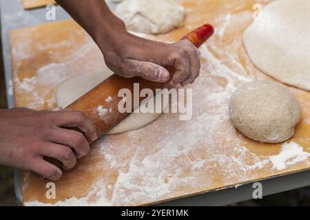 Bilder während einer Brot und Pizza backen Workshop mit vielen Menschen aus allen Altersgruppen und Generationen übernommen. Bilder, die im Freien um ein Brotbackofen, eine Stockfoto